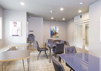 a room with several tables and chairs and a television